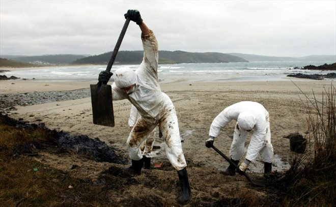 Des bénévoles nettoient une plage contaminée par la marée noire du Prestige à Nemina, dans le nord-ouest de l'Espagne, le 30 novembre 2002