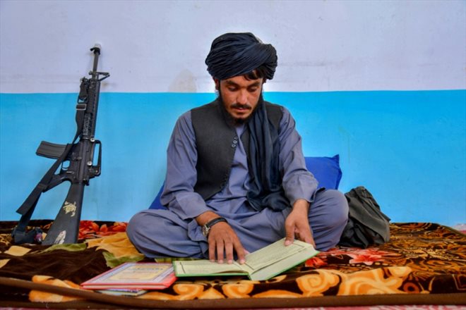 L'officier de police Lal Muhammad lit un livre religieux au quartier général de la police dans le district de Dand à Kandahar, en Afghanistan, le 1er août 2023