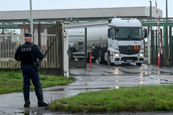 Un CRS surveille la sortie d'un camion-citerne du dépôt TotalEnergies de Flandres, le 13 octobre 2022 à Mardyck, dans le Nord