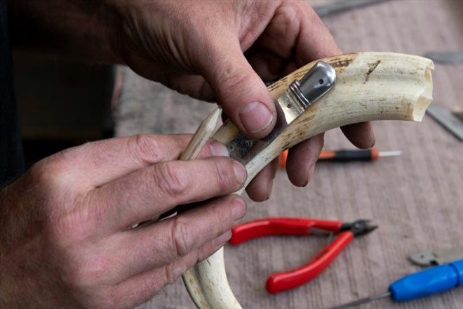 Un employé prépare le manteau d'un couteau Laguiole à la coutellerie Fontenille Pataud, le 12 mais 2022 à Thiers