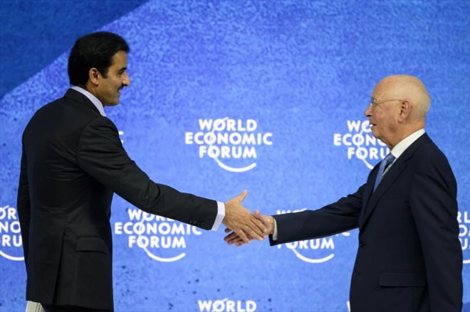 L'émir du Qatar, cheikh Tamim bin Hamad al-Thani (à gauche), serre la main du fondateur et président du Forum économique mondial de Davos (Suisse), Klaus Schwab, lors de la réunion annuelle de l'organisation le 23 mai 2022