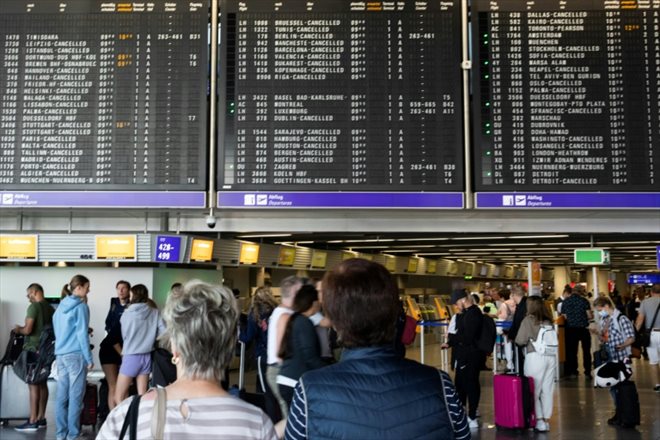 Des voyageurs regardent un tableau d'information sur les vols à l'aéroport de Francfort lors d'une grève des pilotes de la Lufthansa, le 2 septembre 2022 en Allemagne