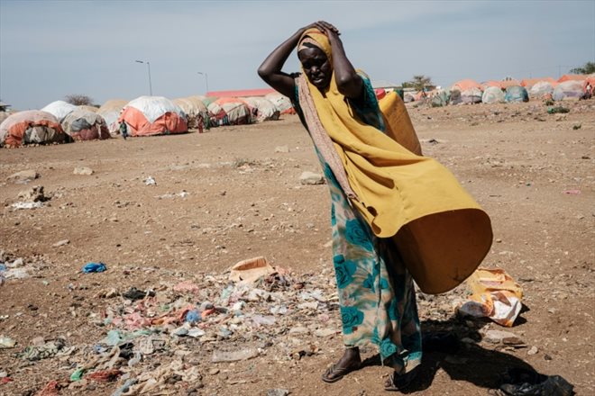 Une femme porte un jerrican d'eau vers le camp de déplacés de Baidoa, en Somalie, le 13 février 2022