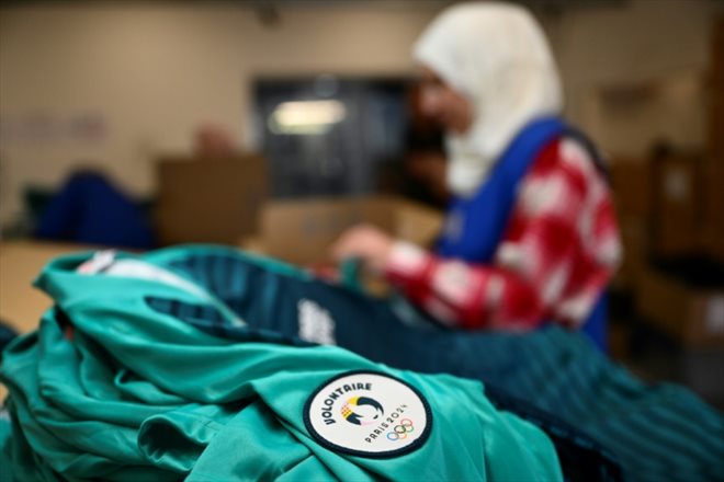 Une employée travaille sur des vêtements pour les volontaires des Jeux olympiques et paralympiques de Paris, le 18 mars 2024, à Marseille