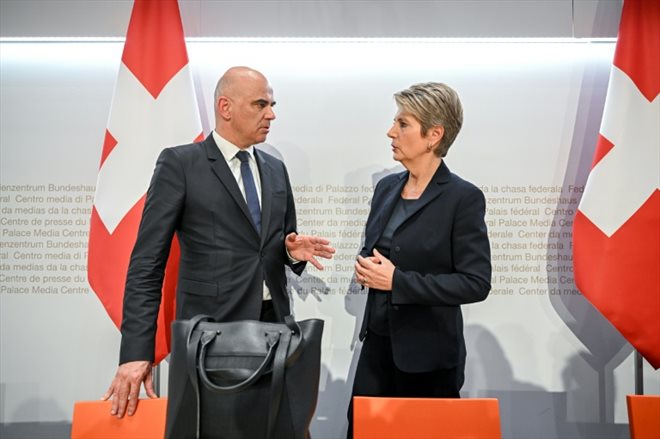 Le président suisse Alain Berset s'entretient avec la ministre suisse des Finances Karin Keller-Sutter, à Berne, le 19 mars 2023