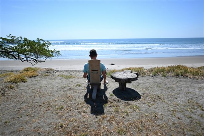 L'Américain Corbin Keegan assis face à la mer à Playa Blanca, le 11 janvier 2024 au Salvador