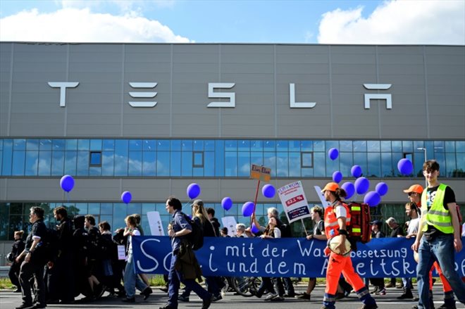 Des manifestants écologistes défilent devant l'usine de Tesla à Grünheide (près de Berlin, en Allemagne) pour protester contre un projet d'agrandissement, le 11  mai 2024