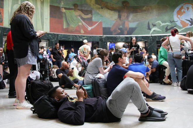 Des voyageurs attendent un vol pendant une panne informatique mondiale à l'aéroport de LaGuardia, le 19 juillet 2024 à New York