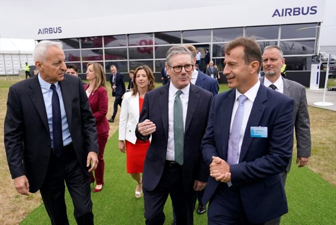 Le Premier ministre britannique Keir Starmer (au centre) discute avec le patron d'Airbus Guillaume Faury, lors du salon de Farnborough, près de Londres, le 22 juillet 2024