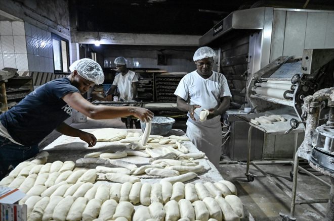 Les employés de la boulangerie mélangent farines de blé et de manioc pour fabriquer leurs baguettes, à Abidjan le 24 juin 2022