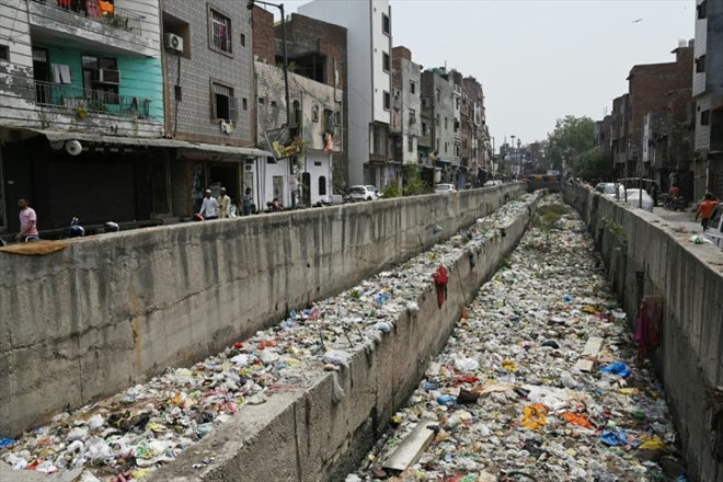 Un égout pluvial rempli d'ordures à Seelampur, quartier de New Delhi, le 26 avril 2023