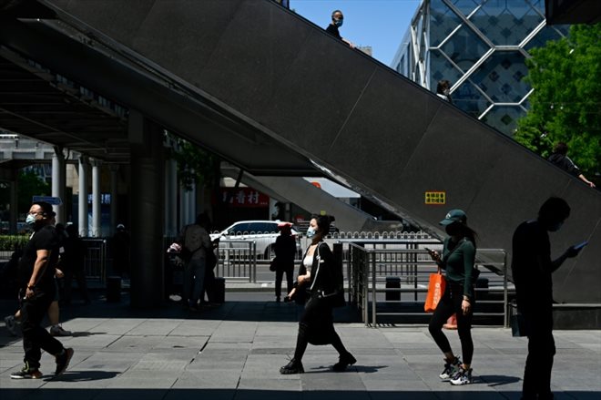 Des piétons dans le quartier d'afaires de Pékin, le 16 mai 2022