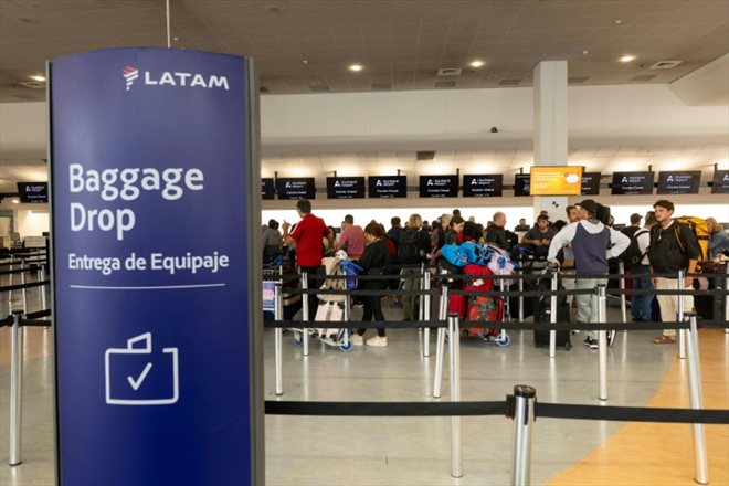 Des voyageurs au comptoir de la Latam Airlines à l'aéroport d'Auckland, au lendemain d'un incident technique sur un Boeing 787 de la compagnie, le 12 mars 2024 en Nouvelle-Zélande