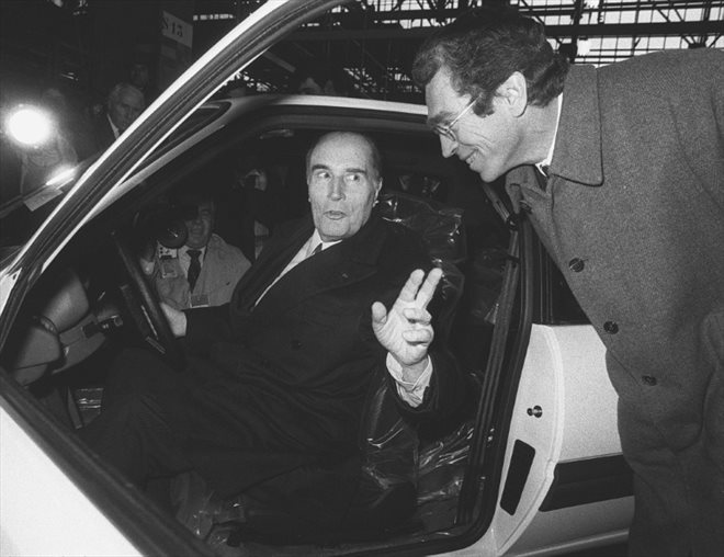 Le président de la République François Mitterrand est installé au volant de la 500.000ème 205 dans les usines Peugeot à Mulhouse, sous le regard amusé du ministre de l'Intérieur Pierre Joxe, lors d'un voyage officiel en Alsace, le 22 novembre 1984