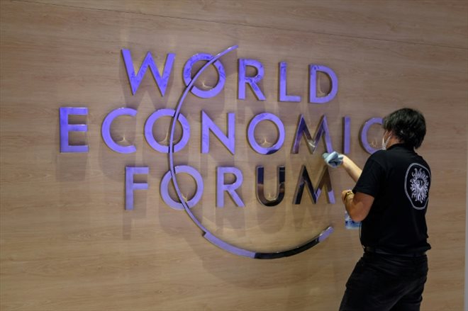 Une employée nettoie le logo du Forum économique mondial (WEF) à l'intérieur du centre des congrès de Davos, en Suisse, le 22 mai 2022
