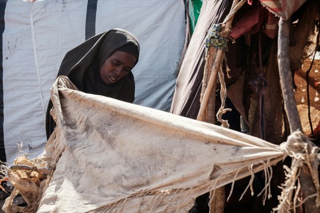 Salado Adan Mohamed, une mère de famille de 26 ans, arrange son abri de fortune dans le camp de déplacés de Muuri à Baidoa (Somalie), le 13 février 2022