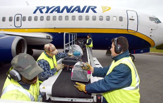 Des bagagistes chargent des valises d'un vol de Ryanair, le 14 avril 2003 sur le tarmac de l'aéroport de Paris-Beauvais-Tillé  