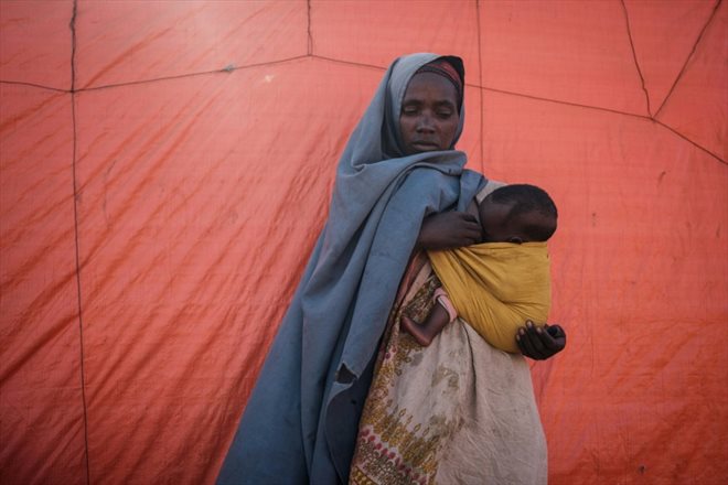 Une femme de 30 ans tient dans les bras son enfant d'un an dans le camp de déplacés de Muuri à Baidoa (Somalie), le 13 février 2022