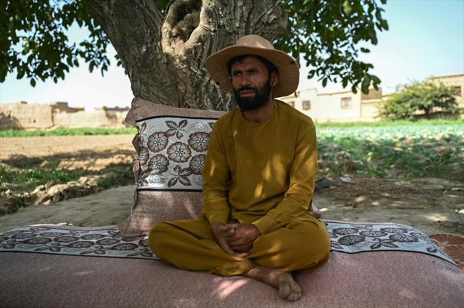 Rahatullah Azizi, fermier, répond à une interview avec l'AFP, près d'un champ de choux-fleurs dans le village de Tilanchi de la province de Parwan, en Afghanistan, le 3 août 2023