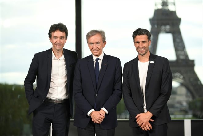 Antoine (g) et Bernard Arnault (c) du groupe LVMH et Tony Estanguet, président du comité d'organisation des JO de Paris, après la désignation de LVMH comme partenaire premium des Jeux olympiques et paralympiques de Paris 2024, le 24 juillet 2023 à Paris 