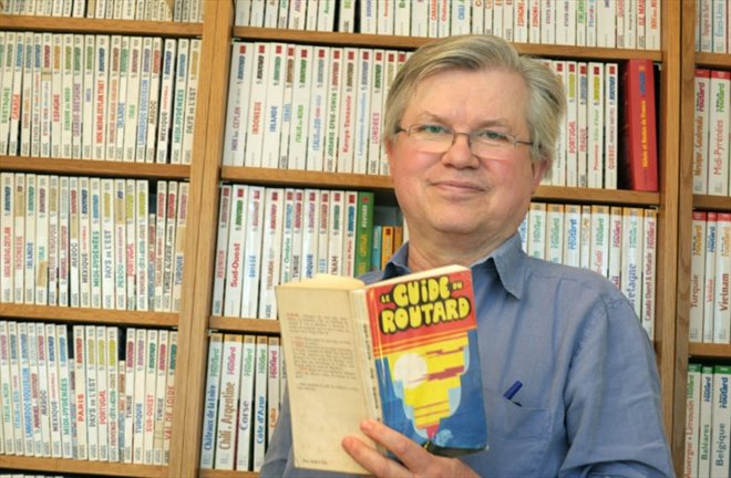 Philippe Gloaguen, fondateur du Routard, montre le premier exemplaire de son guide, à Paris
