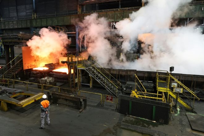 En six ou sept passages sous les rouleaux et les jets d'eau, la barre de métal en fusion de 25 centimètres d'épaisseur s'aplatit et s'allonge en un long et fin ruban d'acier qui servira à fabriquer la torche olympique, dans le laminoir d'ArcelorMittal à Florange, le 4 avril 2024 
