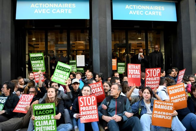 Des militants d'ONG environnementales à l'entrée de la salle Pleyel où se tient l'assemblée générale des actionnaires de TotalEnergies, le 25 mai 2022