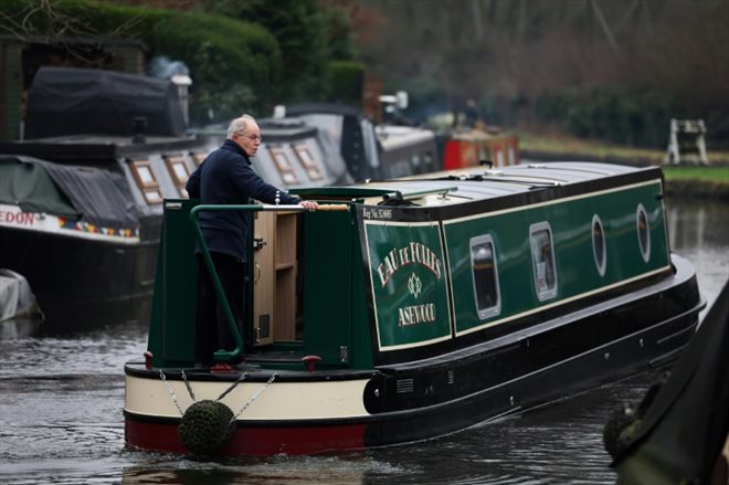 Neil Cocksedge, à bord de sa péniche hybirde Eau de Folles, navigue sur un canal de plaisance d'Ashwood, le 25 janvier 2024 dans le centre de l'Angleterre