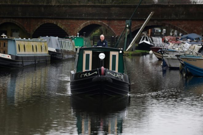 Neil Cocksedge, à bord de sa péniche hybride Eau de Folles, navigue sur un canal de plaisance d'Ashwood, le 25 janvier 2024 dans le centre de l'Angleterre