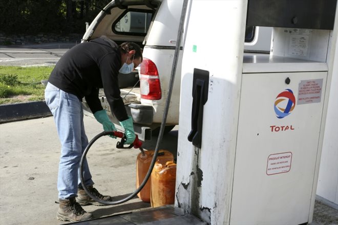 Un conducteur remplit des bidons d'essence le 14 février 2022 à Lucciana, en Corse 
