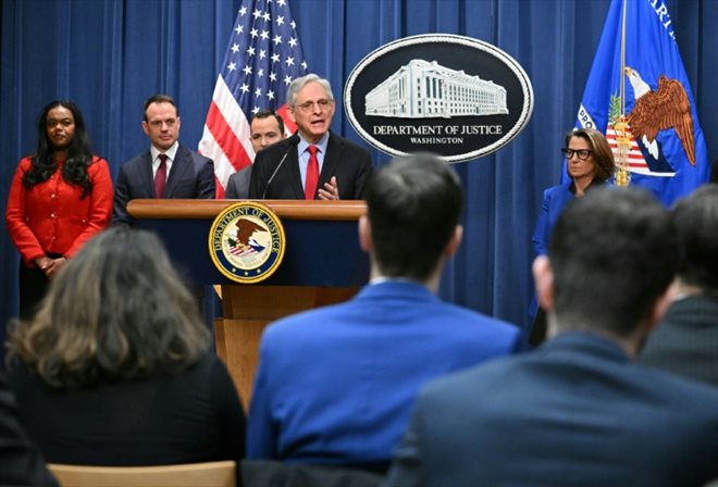 Le ministre américain de la Justice, Merrick Garland (c) lors d'une conférence de presse annonçant un procès antitrust contre Apple, le 21 mars 2024 à Washington