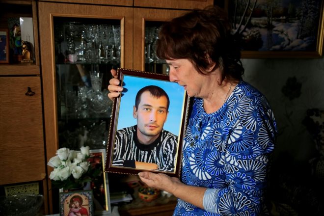 Galina Inkina tient un portrait de son fils Denis Inkine, mineur chez ArcelorMittal tué dans un accident en novembre 2022, chez elle à Chakhtinsk, dans le centre du Kazakhstan le 8 septembre 2023