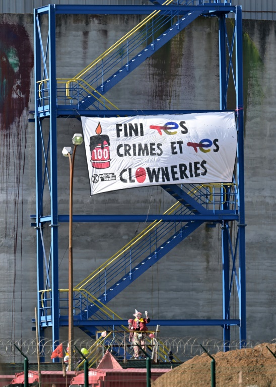 Des militants d'Extinction Rebellion (ER) déguisés en clowns sur le site de la raffinerie de TotalEnergies à Donges (Loire-Atlantique) le 23 mars 2024