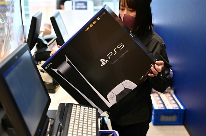 Une vendeuse montre, le 12 novembre 2020, une console Sony PlayStation 5 à Kawasaki, au Japon