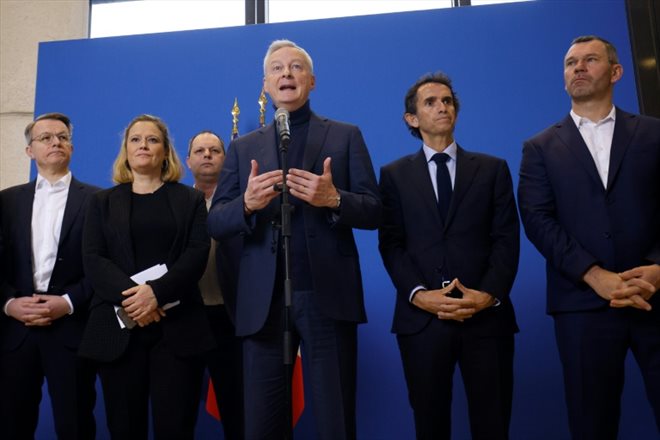Le ministre de l'Economie et des Finances Bruno Le Maire (au centre) et la ministre déléguée aux PME, au Commerce et à l'Artisanat Olivia Grégoire (à gauche) avec à leur côté les principaux patrons de la distribution alimentaire, le 6 mars 2023, lors d'une conférence de presse au ministère de l'Economie à Paris  