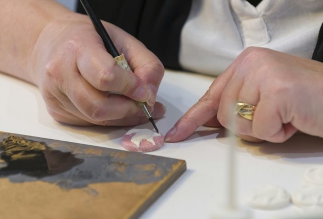 Une ouvrière peint des fèves à la main dans un atelier d'Autreville, dans les Vosges, le 3 novembre 2016