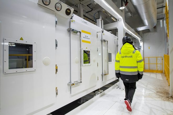 Un employé passe devant la section des fours de revêtement de l'usine Northvolt Ett à Skelleftea, le 23 février 2022 dans le nord de la Suède