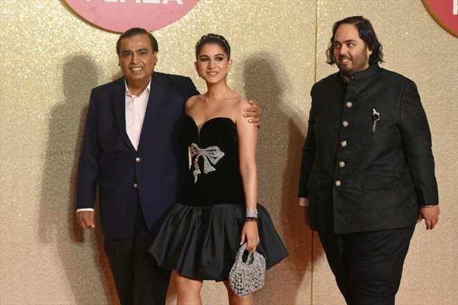 Le PDG de Reliance Industries, le milliardaire indien Mukesh Ambani (G) avec sa future belle-fille Radhika Merchant (C) et son fils Anant Ambani (D) à Bombay le 31 octobre 2023