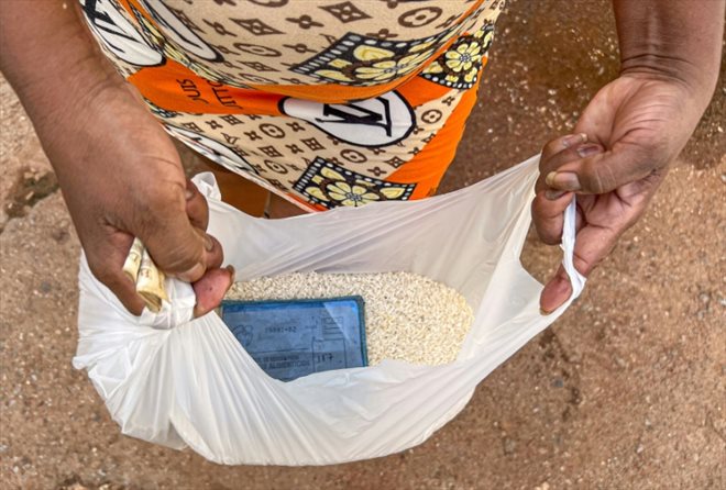 Une Cubaine montre la ration mensuelle de riz attribuée à sa famille comme part des aliments prévus dans le carnet de rationnement, le 17 septembre à La Havane