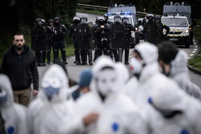 Des militants du groupe écologiste français Les Soulevements de la Terre (SLT) dispersés par des policiers après avoir manifesté devant un site Lafarge à Saint-Herblain, le 11 décembre 2023 en Loire-Atlantique