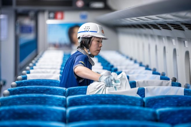 Un membre du personnel nettoie l'intérieur d'un train au dépôt Shinkansen de la compagnie JR Central dans le district de Shinagawa, à Tokyo, le 24 juillet 2024