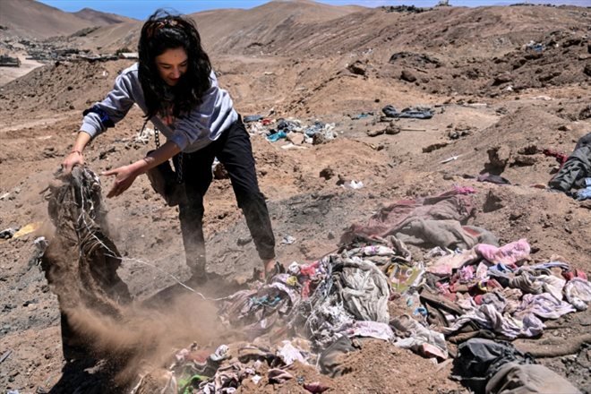 L'avocate Paulin Silva montre des vêtements jetés dans le désert, dans le secteur La Pampa d'Alto Hospicio, au Chili, le 11 novembre 2022
