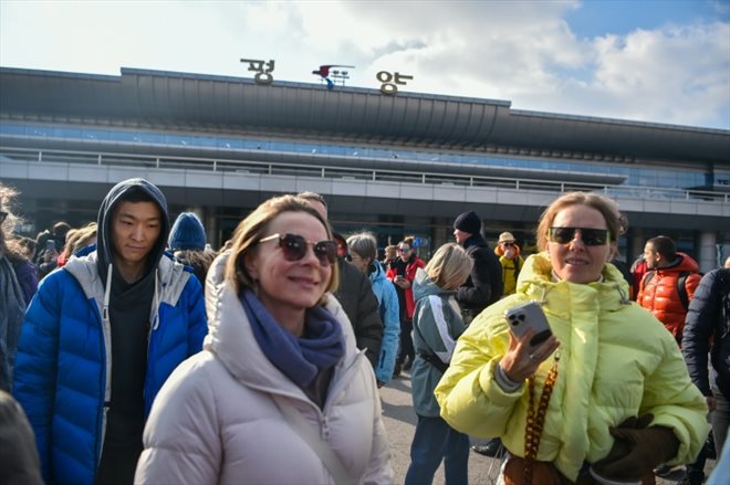 Des touristes russes devant l'aéroport international de Pyongyang, le 9 février 2024 en Corée du Nord