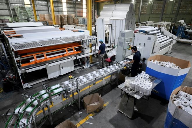 Un employé surveille la ligne de production de rouleaux de papier toilette dans l'usine Papelera Rosato à Berazategui, province de Buenos Aires, le 15 avril 2024 en Argentine