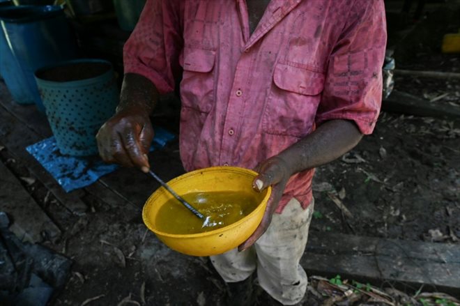Un homme montre le processus de production de pâte de coca dans un laboratoire près de la municipalité d'Olaya Herrera, en Colombie, le 12 mai 2023