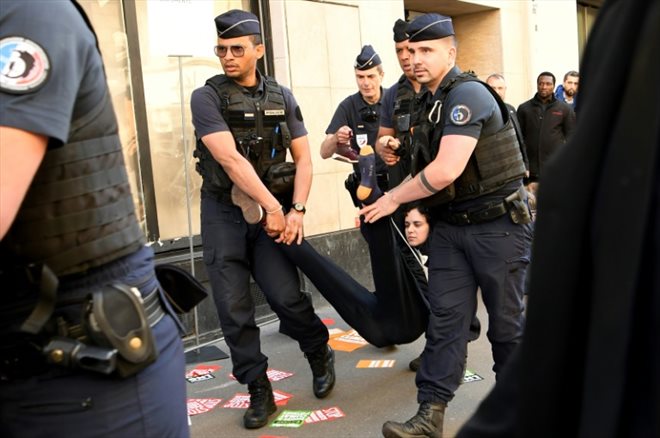 Des policiers délogent des manifestants qui bloquent l'accès à l'Assemblée générale des actionnaires de TotalEnergies, le 25 mai 2022 à Paris