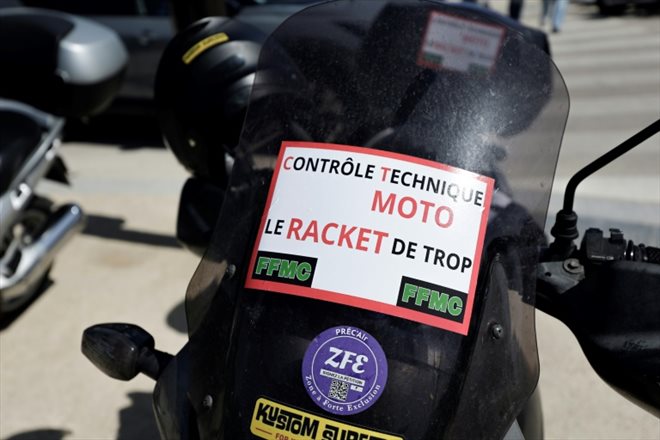 Contrôle technique moto: le racket de trop, indique l'affiche déposée sur la moto d'un manifestant le 13 avril 2024 à Paris