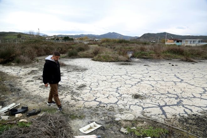 Adriatik Golemi, journaliste et membre de l'association locale pour la protection de l'environnement, dans un champ contaminé, le 9 janvier 2023 à Zharrëz, en Albanie