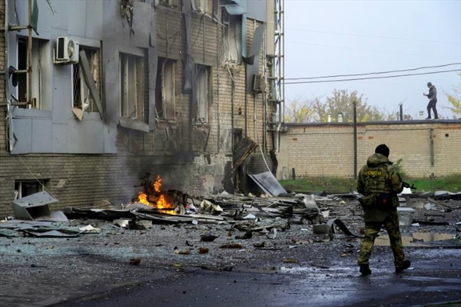 Un soldat sur le site d'une explosion à la voiture piégée devant un immeuble abritant une chaîne de télévision locale, dans la ville de Melitopol sous autorité prorusse, le 25 octobre 2022 dans le sud de l'Ukraine