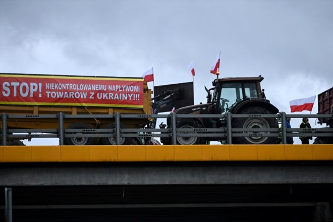 Une banderole Arrêt à l'approvisionnement incontrôlé de marchandises en provenance d'Ukraine accrochée à un semi-remorque pendant le blocage par des agriculteurs polonais de l'autoroute reliant Varsovie à Lublin, près de Ryki, le 20 février 2024